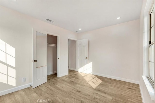 unfurnished bedroom featuring a closet and light hardwood / wood-style flooring