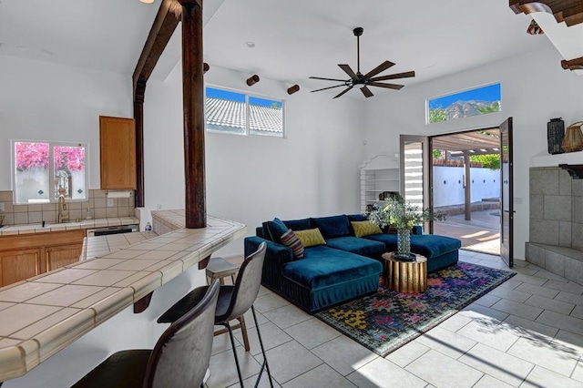 tiled living room with ceiling fan and sink