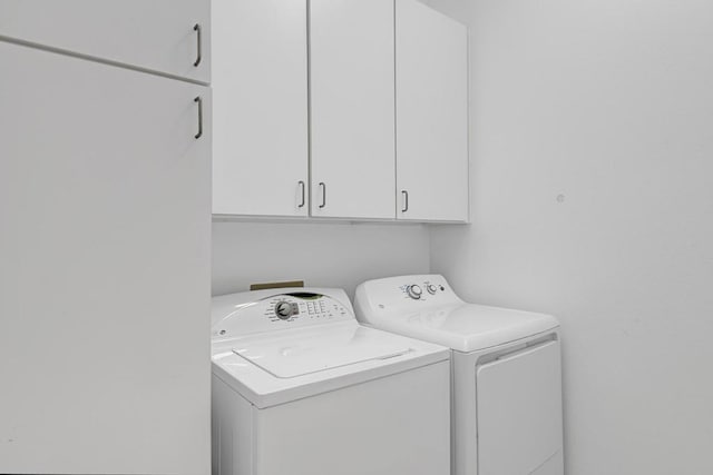 laundry room with cabinets and washing machine and clothes dryer