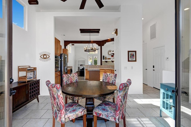 dining space with a fireplace, light tile patterned flooring, and ceiling fan with notable chandelier