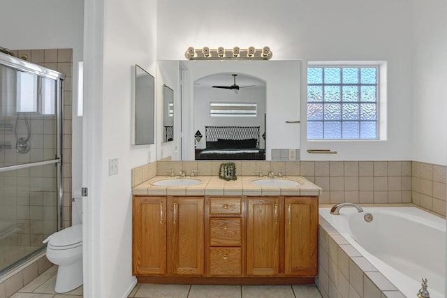 full bathroom with toilet, vanity, ceiling fan, tile patterned floors, and shower with separate bathtub