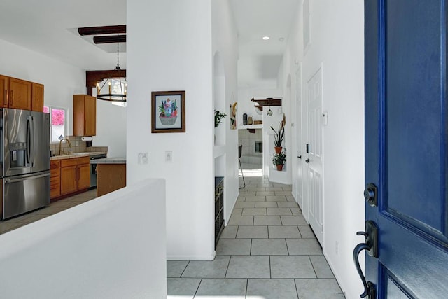 kitchen with pendant lighting, decorative backsplash, sink, appliances with stainless steel finishes, and light tile patterned floors