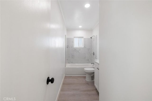 full bathroom featuring toilet, hardwood / wood-style floors, tiled shower / bath, ornamental molding, and vanity