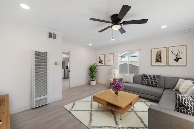 living room featuring ceiling fan and light hardwood / wood-style flooring