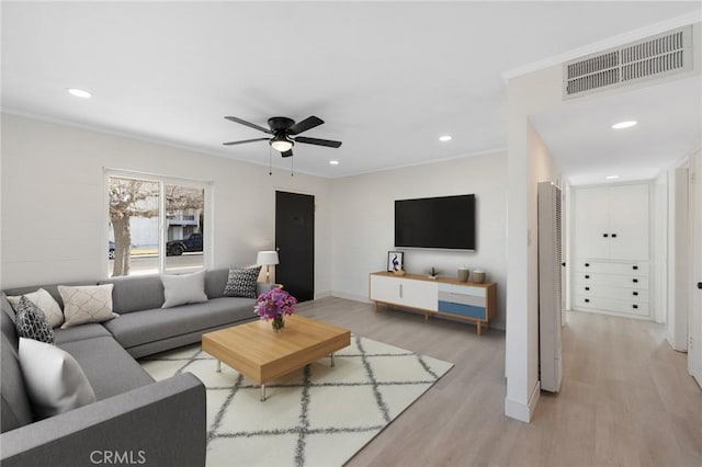 living room featuring ceiling fan, crown molding, and light hardwood / wood-style floors