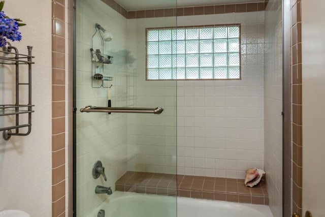 bathroom featuring combined bath / shower with glass door