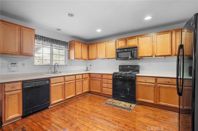 kitchen featuring light hardwood / wood-style floors, sink, and black appliances