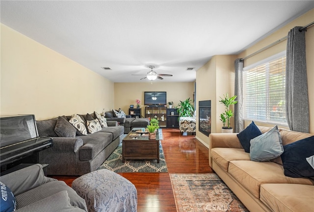 living room with ceiling fan and dark wood-type flooring