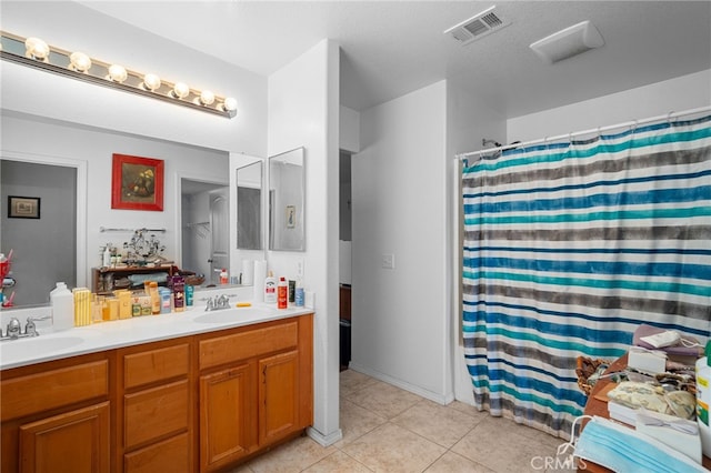 bathroom with tile patterned flooring, walk in shower, and vanity