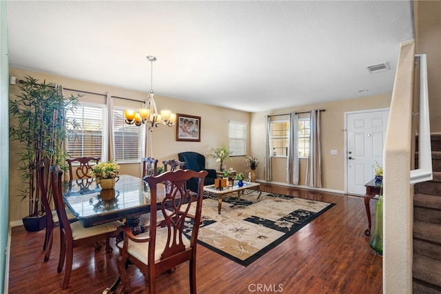 dining room featuring dark hardwood / wood-style floors and an inviting chandelier