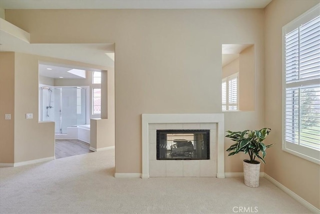 unfurnished living room with light carpet and a fireplace