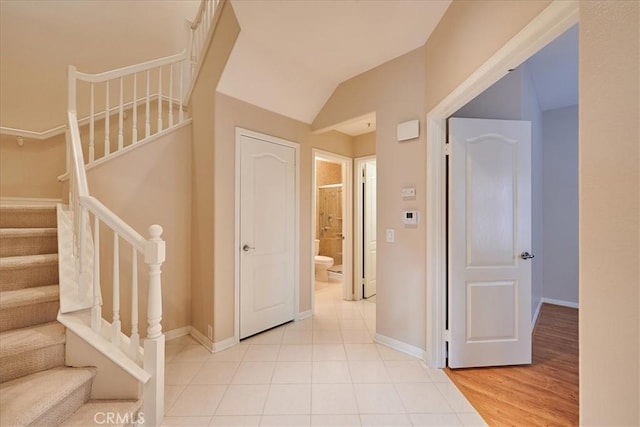 interior space featuring light tile patterned floors and lofted ceiling