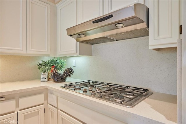 kitchen with decorative backsplash, white cabinets, and stainless steel gas cooktop