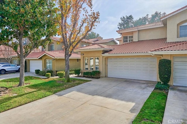 multi unit property with an attached garage, a tile roof, and stucco siding