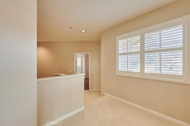 hall with carpet floors, attic access, an upstairs landing, and baseboards