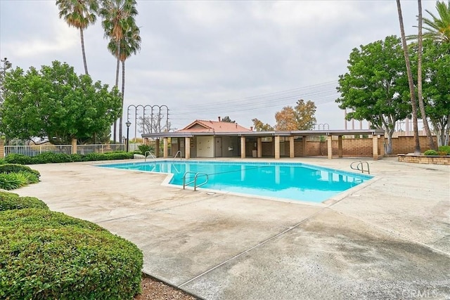 community pool with fence and a patio