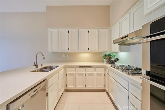 kitchen with appliances with stainless steel finishes, light countertops, a sink, and under cabinet range hood