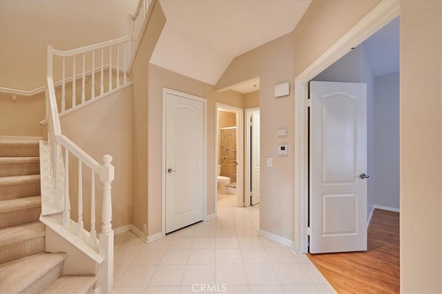 interior space featuring light wood-style floors, stairs, and baseboards