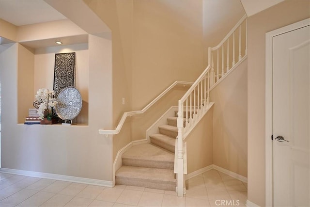 staircase featuring baseboards and tile patterned floors