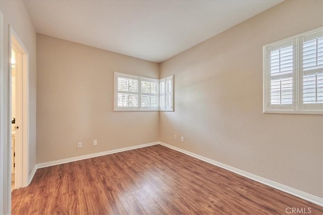 empty room featuring baseboards and wood finished floors