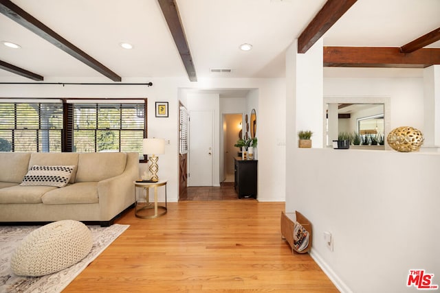 living room featuring light hardwood / wood-style floors and beamed ceiling