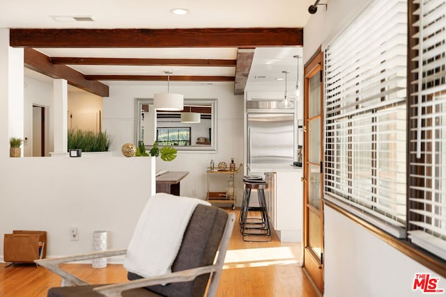 interior space featuring light wood-type flooring and beam ceiling