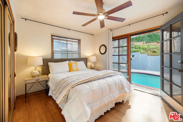 bedroom featuring ceiling fan, access to exterior, multiple windows, and hardwood / wood-style flooring