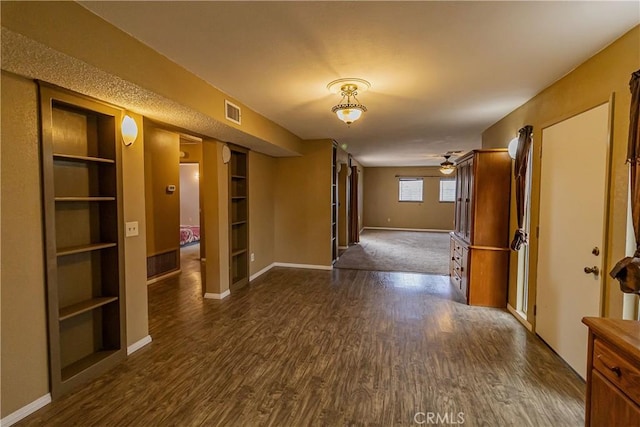 corridor with dark hardwood / wood-style flooring and built in features