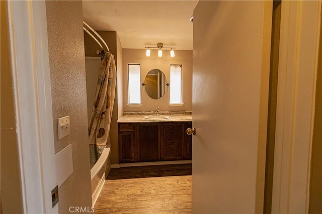 bathroom with shower / tub combo with curtain, vanity, and hardwood / wood-style floors