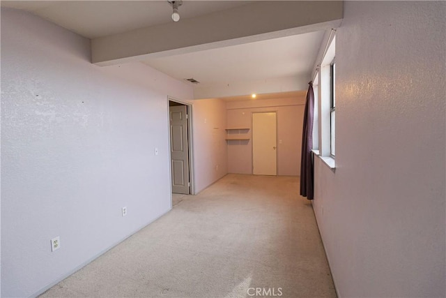 unfurnished room featuring light carpet