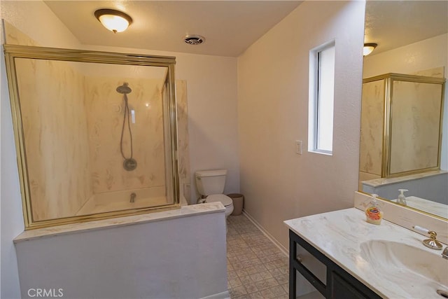 bathroom with vanity, a shower with shower door, and toilet