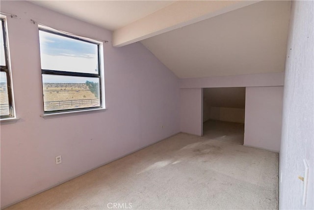 additional living space featuring light colored carpet and lofted ceiling with beams