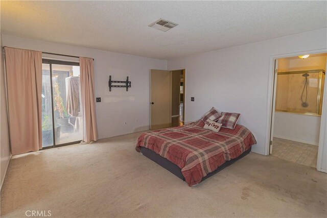 carpeted bedroom featuring access to exterior, a textured ceiling, and ensuite bath