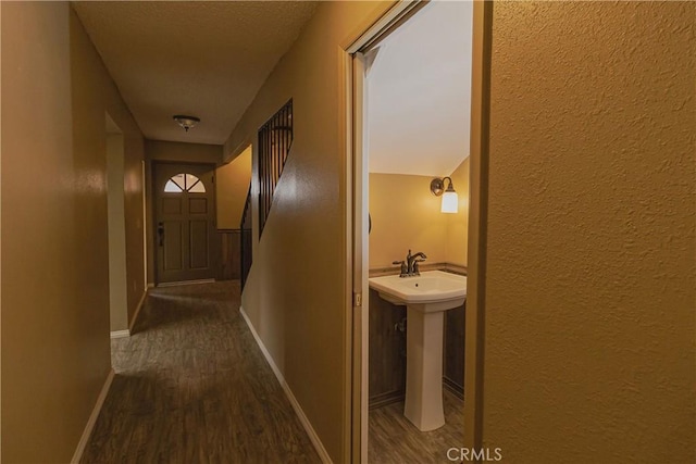 corridor featuring dark wood-style flooring and baseboards