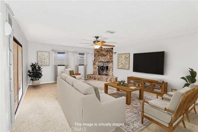 living area with light carpet, a fireplace, visible vents, a ceiling fan, and baseboards