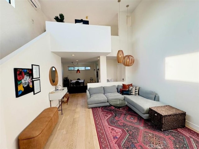 living room with light wood-type flooring and a towering ceiling