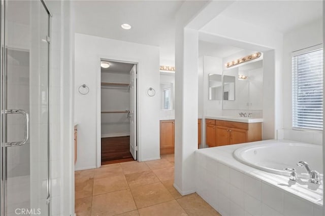 bathroom featuring tile patterned flooring, shower with separate bathtub, and vanity