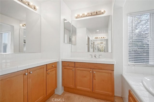 bathroom with tile patterned flooring, vanity, a healthy amount of sunlight, and a bath