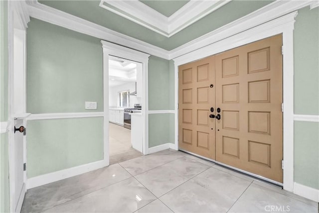 tiled entrance foyer featuring crown molding and a tray ceiling