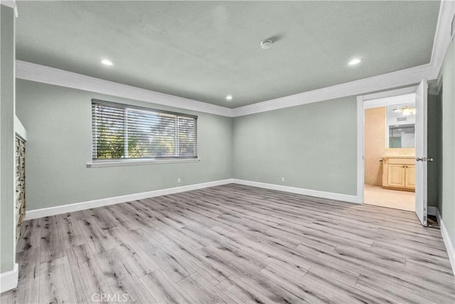 interior space with ensuite bathroom, light hardwood / wood-style flooring, and crown molding