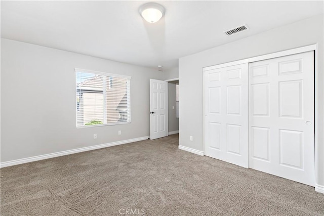 unfurnished bedroom with a closet and carpet flooring