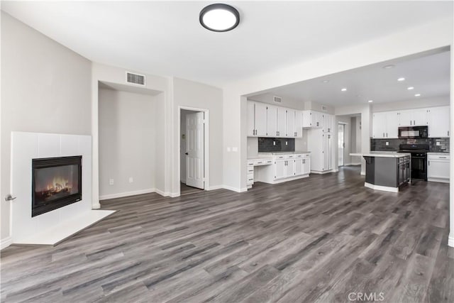 unfurnished living room featuring dark wood-type flooring