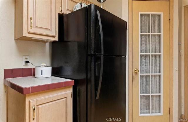 146 N Polk St, Lakeport, CA 95453 - kitchen featuring black refrigerator, light brown cabinetry, and tile countertops