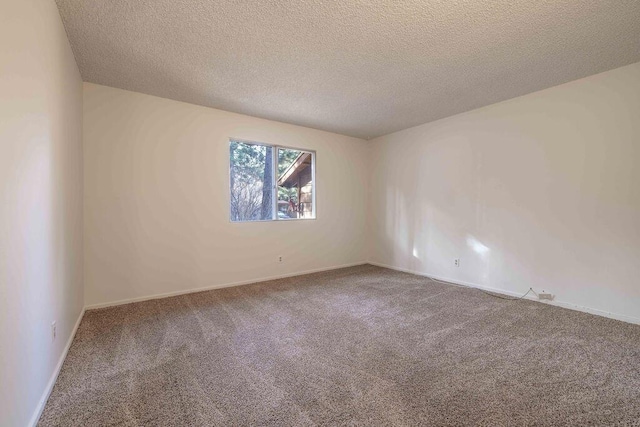 empty room featuring a textured ceiling and carpet flooring