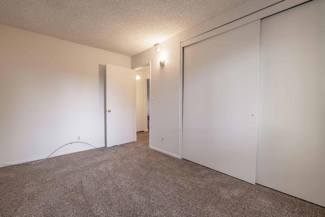 unfurnished bedroom featuring carpet, a closet, and a textured ceiling