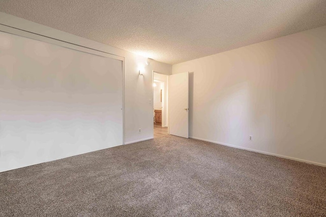 unfurnished room featuring carpet and a textured ceiling