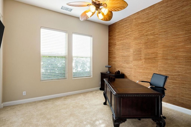 carpeted home office featuring ceiling fan