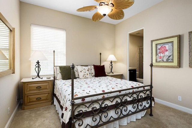 bedroom featuring ceiling fan, light colored carpet, multiple windows, and connected bathroom