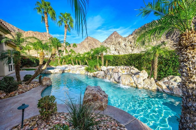 view of swimming pool featuring pool water feature and a mountain view