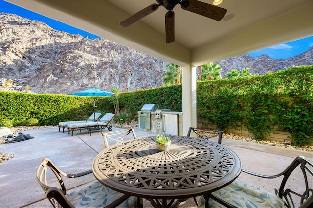 view of patio with ceiling fan, a mountain view, and area for grilling